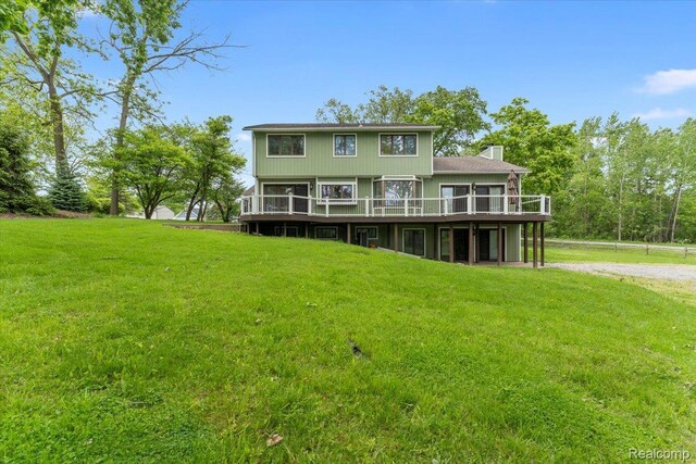 10161 N Loma Cir, Grosse Ile, MI 48138 - back of property with a wooden deck, a lawn, and a chimney