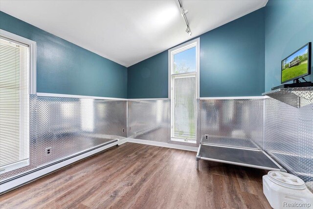 10161 N Loma Cir, Grosse Ile, MI 48138 - miscellaneous room featuring a baseboard radiator, wood finished floors, vaulted ceiling, track lighting, and wainscoting