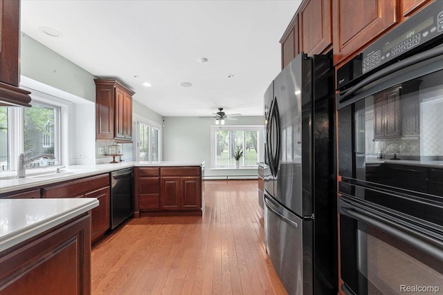 10161 N Loma Cir, Grosse Ile, MI 48138 - kitchen with freestanding refrigerator, stainless steel dishwasher, light wood-style floors, light countertops, and a sink