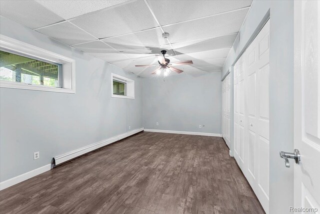 10161 N Loma Cir, Grosse Ile, MI 48138 - unfurnished bedroom with a baseboard heating unit, a paneled ceiling, wood finished floors, baseboards, and a ceiling fan