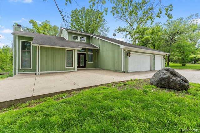 10161 N Loma Cir, Grosse Ile, MI 48138 - mid-century modern home featuring a garage, concrete driveway, and a chimney