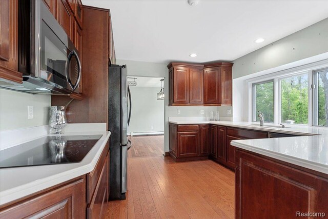 10161 N Loma Cir, Grosse Ile, MI 48138 - kitchen with freestanding refrigerator, a sink, light countertops, light wood-style floors, and recessed lighting