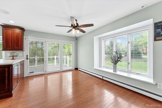 10161 N Loma Cir, Grosse Ile, MI 48138 - unfurnished living room with a baseboard radiator, healthy amount of natural light, ceiling fan, light wood-style flooring, and recessed lighting