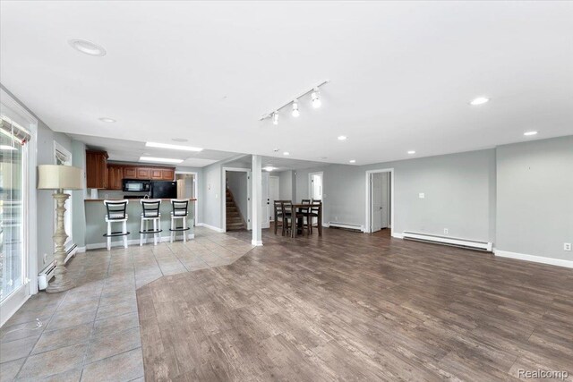 10161 N Loma Cir, Grosse Ile, MI 48138 - living room with a baseboard heating unit, light wood-style floors, baseboard heating, recessed lighting, and baseboards