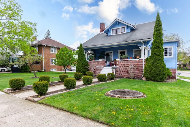 323 Northbound Gratiot Ave, Mount Clemens, MI 48043 - bungalow with stairway, a chimney, a front yard, covered porch, and brick siding
