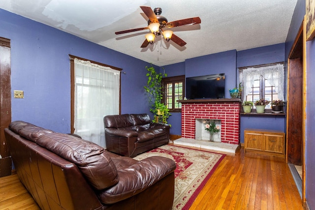 323 Northbound Gratiot Ave, Mount Clemens, MI 48043 - living area featuring hardwood / wood-style flooring, a brick fireplace, and a ceiling fan