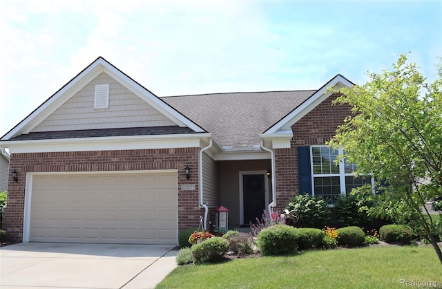 23971 Manistee Ln, Flat Rock, MI 48134 - view of front facade with brick siding, driveway, a garage, and roof with shingles