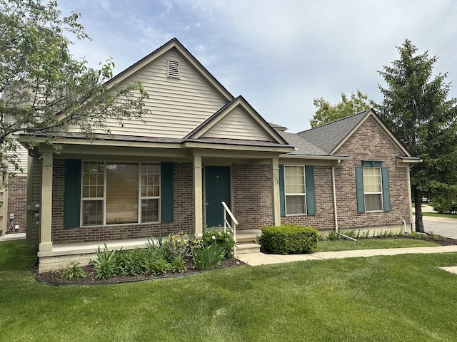 128 Commons Cir, Saline, MI 48176 - ranch-style house featuring brick siding, a front yard, and covered porch