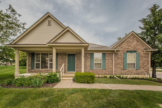 128 Commons Cir, Saline, MI 48176 - view of front of home featuring brick siding, covered porch, and a front lawn