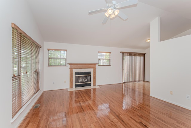128 Commons Cir, Saline, MI 48176 - unfurnished living room with vaulted ceiling, light wood-style floors, a fireplace with flush hearth, a ceiling fan, and baseboards