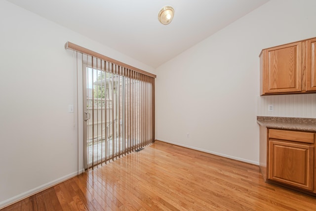 128 Commons Cir, Saline, MI 48176 - spare room with light wood-style floors, lofted ceiling, and baseboards
