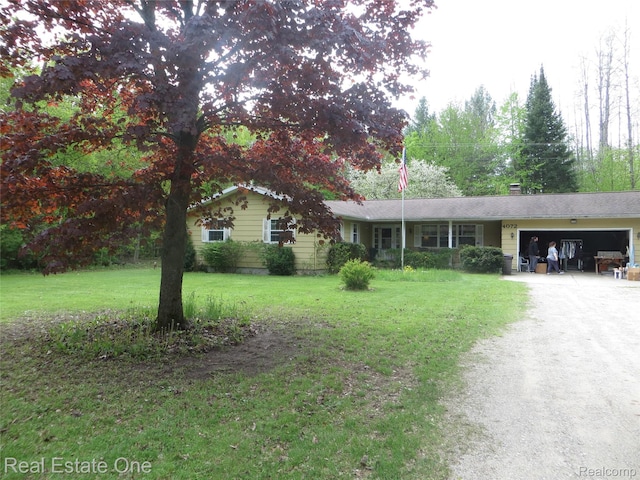 4072 M 55, Cadillac, MI 49601 - single story home with driveway, an attached garage, a front yard, and a chimney