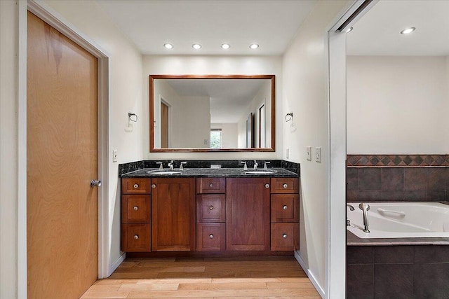 2 Eastbury Ct, Ann Arbor, MI 48105 - bathroom featuring double vanity, wood finished floors, a bath, and baseboards