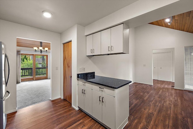 2 Eastbury Ct, Ann Arbor, MI 48105 - kitchen featuring a heating unit, a chandelier, freestanding refrigerator, vaulted ceiling, and white cabinetry
