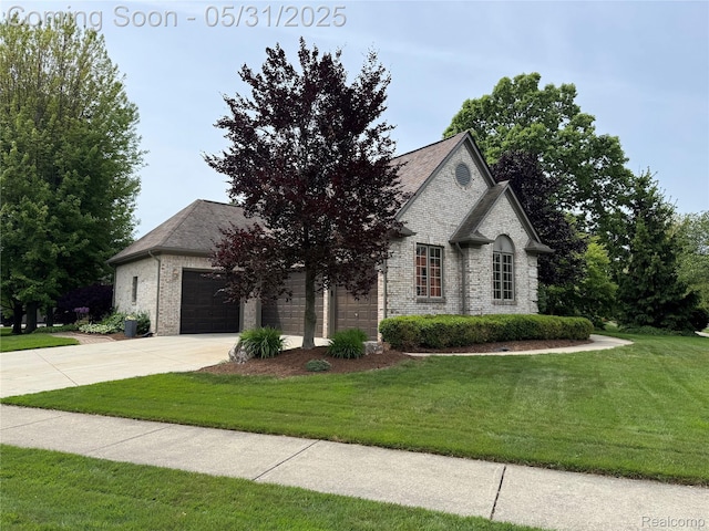 7348 William Dr, Shelby Twp, MI 48316 - french country home featuring driveway, a front yard, brick siding, and a garage