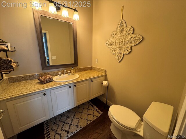 7348 William Dr, Shelby Twp, MI 48316 - half bath with toilet, wood finished floors, and vanity