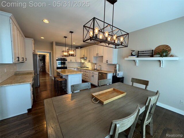 7348 William Dr, Shelby Twp, MI 48316 - dining area featuring a chandelier, dark wood-style floors, recessed lighting, and baseboards