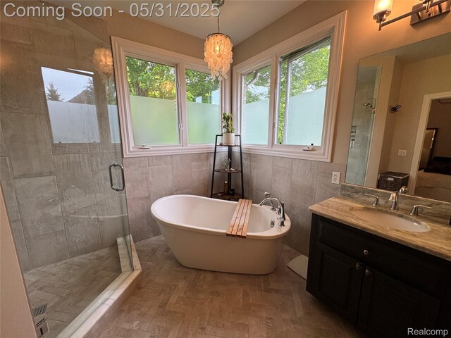 7348 William Dr, Shelby Twp, MI 48316 - bathroom featuring a shower stall, a soaking tub, vanity, and tile walls