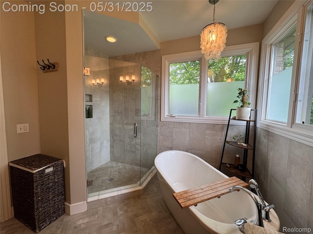 7348 William Dr, Shelby Twp, MI 48316 - full bath featuring plenty of natural light, a soaking tub, a stall shower, tile walls, and a chandelier