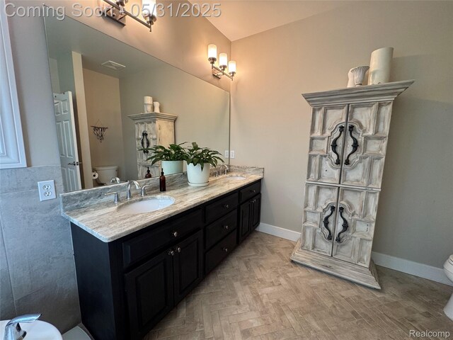 7348 William Dr, Shelby Twp, MI 48316 - bathroom with toilet, double vanity, and baseboards