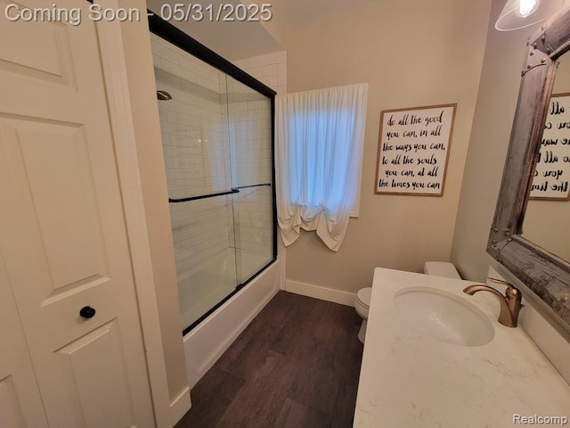 7348 William Dr, Shelby Twp, MI 48316 - full bathroom with toilet, baseboards, wood finished floors, bath / shower combo with glass door, and vanity