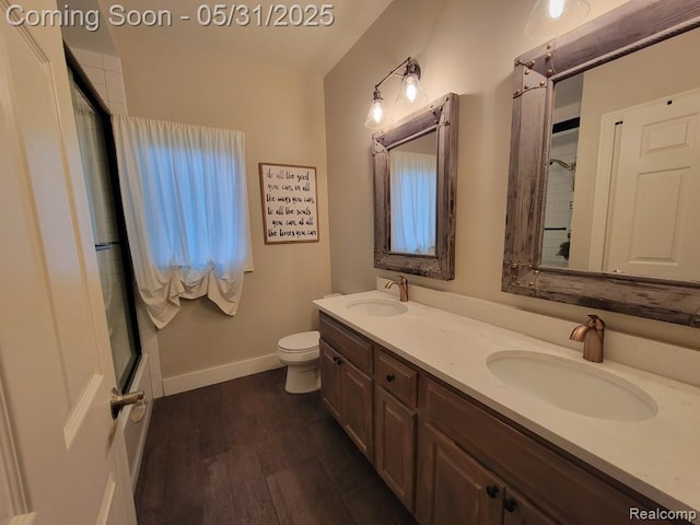 7348 William Dr, Shelby Twp, MI 48316 - full bath featuring a shower with shower door, toilet, double vanity, wood finished floors, and baseboards