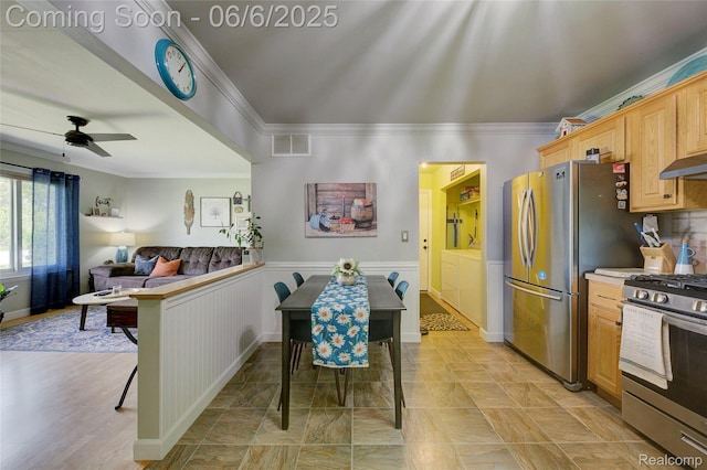 2470 E Highland Rd, Howell, MI 48843 - kitchen with independent washer and dryer, stainless steel appliances, ornamental molding, ceiling fan, and a wainscoted wall