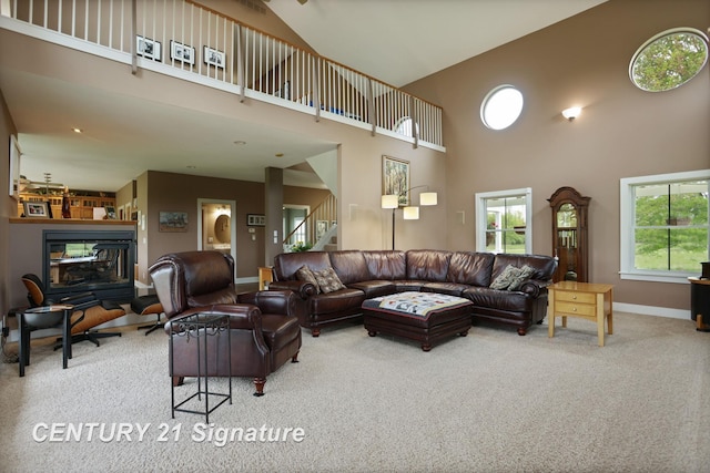 12751 Wilkinson Rd, Freeland, MI 48623 - living area with a towering ceiling, carpet floors, baseboards, a glass covered fireplace, and stairway