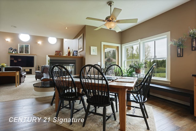 12751 Wilkinson Rd, Freeland, MI 48623 - dining room featuring a fireplace, a ceiling fan, wood finished floors, baseboards, and vaulted ceiling