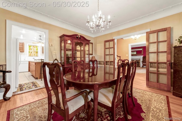 2918 Burns St, Detroit, MI 48214 - dining room with a chandelier, light wood-type flooring, and crown molding