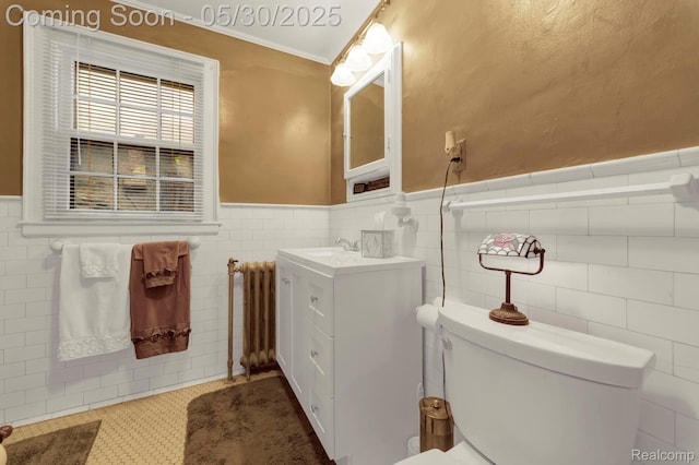 2918 Burns St, Detroit, MI 48214 - bathroom featuring radiator, a wainscoted wall, tile walls, vanity, and toilet