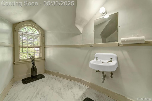 2918 Burns St, Detroit, MI 48214 - bathroom with vaulted ceiling, marble look tiles, baseboards, and a sink