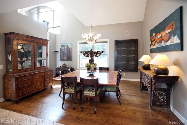 826 Wolverine Dr, Wolverine Lake, MI 48390 - dining space with a chandelier, high vaulted ceiling, wood finished floors, and baseboards