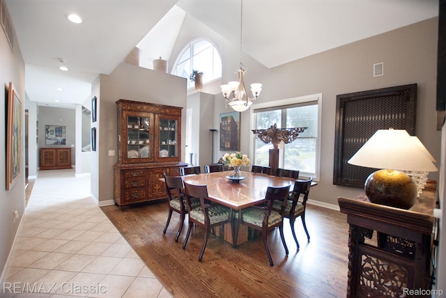 826 Wolverine Dr, Wolverine Lake, MI 48390 - dining space featuring a chandelier, baseboards, a towering ceiling, light wood-style floors, and recessed lighting