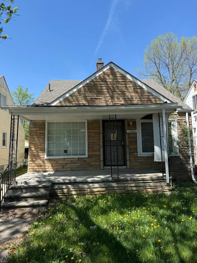 7269 Minock St, Detroit, MI 48228 - bungalow with covered porch, a shingled roof, and a chimney