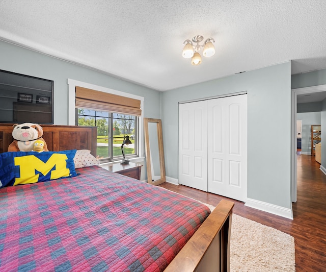 826 Jennie Pl, Monroe, MI 48161 - bedroom with baseboards, a textured ceiling, a closet, and wood finished floors