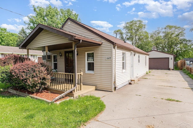 4411 W Michigan Ave, Saginaw, MI 48638 - shotgun-style home featuring a garage, a porch, and an outdoor structure