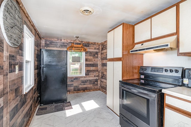 4411 W Michigan Ave, Saginaw, MI 48638 - kitchen with stainless steel electric stove, under cabinet range hood, freestanding refrigerator, wooden walls, and light marble finish floors
