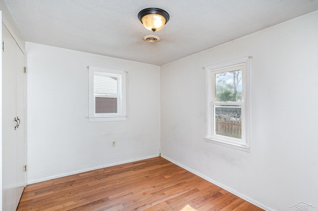 4411 W Michigan Ave, Saginaw, MI 48638 - empty room with light wood-style floors and a textured ceiling