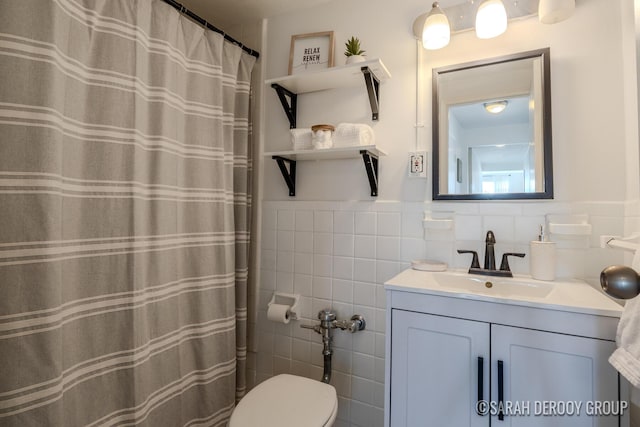 505 Cherry St SE Unit 512, Grand Rapids, MI 49503 - full bathroom with tile walls, vanity, toilet, a wainscoted wall, and curtained shower