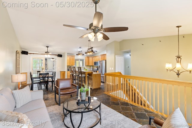 20791 Busenbark Ln, Brownstown, MI 48183 - living area with ceiling fan, stone tile flooring, vaulted ceiling, and a chandelier