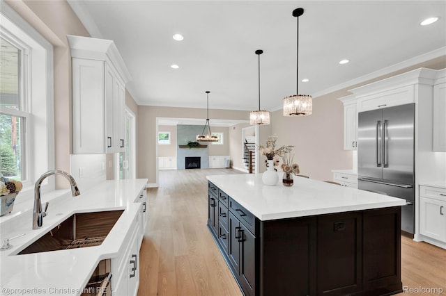19138 Riverside Dr, Beverly Hills, MI 48025 - kitchen with stainless steel built in refrigerator, light wood-type flooring, white cabinetry, plenty of natural light, and crown molding