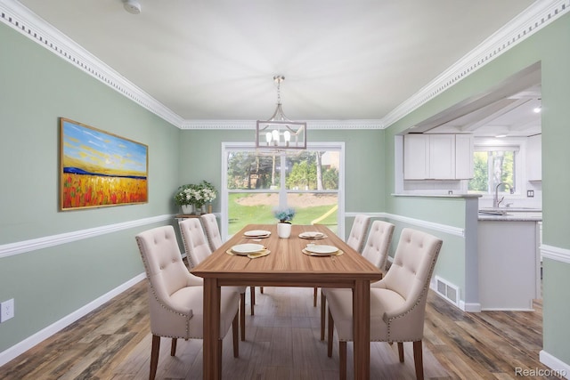667 Heritage Ln, Rochester, MI 48309 - dining space with a chandelier, wood finished floors, crown molding, and baseboards