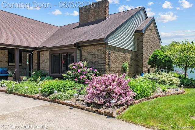 3430 Woodvalley Dr, Lapeer, MI 48446 - view of side of property with brick siding, a chimney, and roof with shingles