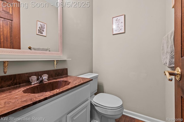 3430 Woodvalley Dr, Lapeer, MI 48446 - half bathroom with vanity, toilet, wood finished floors, and baseboards
