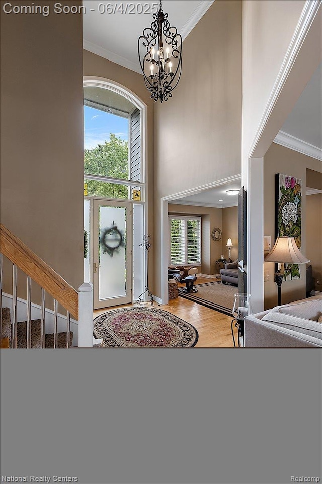 3448 Circle Dr, Commerce Twp, MI 48382 - entryway with crown molding, a chandelier, wood finished floors, a high ceiling, and baseboards