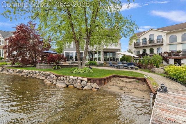 3448 Circle Dr, Commerce Twp, MI 48382 - rear view of house featuring a patio area, a water view, a balcony, and a lawn