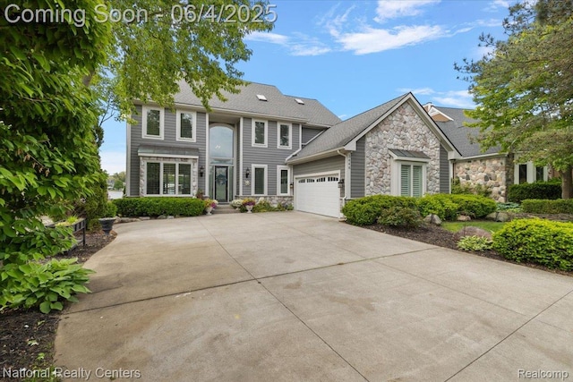 3448 Circle Dr, Commerce Twp, MI 48382 - view of front of property featuring stone siding, a garage, and concrete driveway