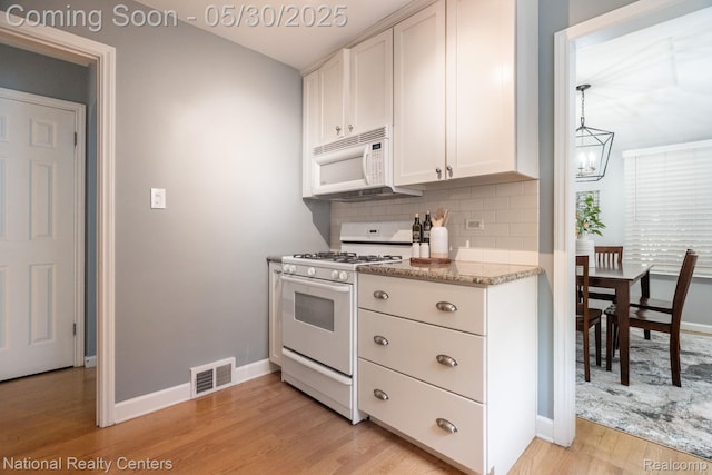 2029 Hubbell St, Dearborn, MI 48128 - kitchen featuring white appliances, light wood finished floors, decorative backsplash, baseboards, and white cabinets