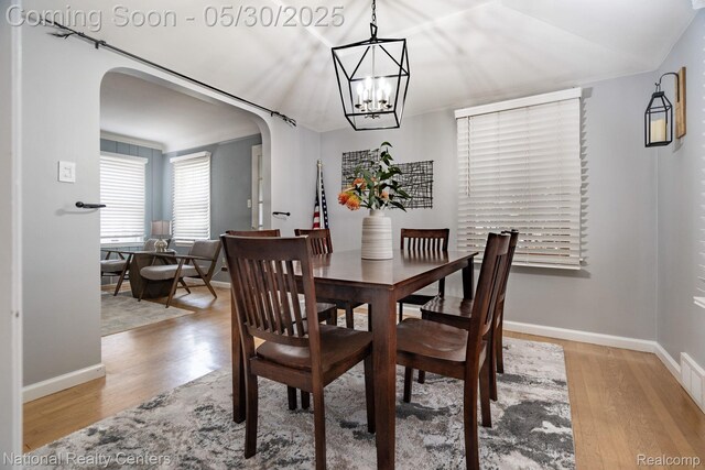 2029 Hubbell St, Dearborn, MI 48128 - dining space featuring arched walkways, wood finished floors, a chandelier, and baseboards